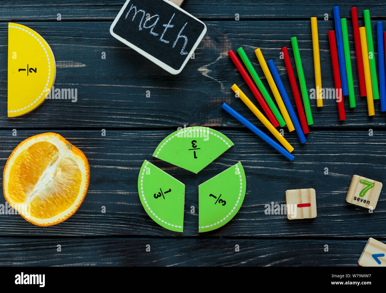 Сolorful mathe Fraktionen und Orangen als Probe auf dunklem Hintergrund oder Tabelle. Interessante kreative lustige Mathe für Kids. Bildung, zurück zu schoo Stockfoto