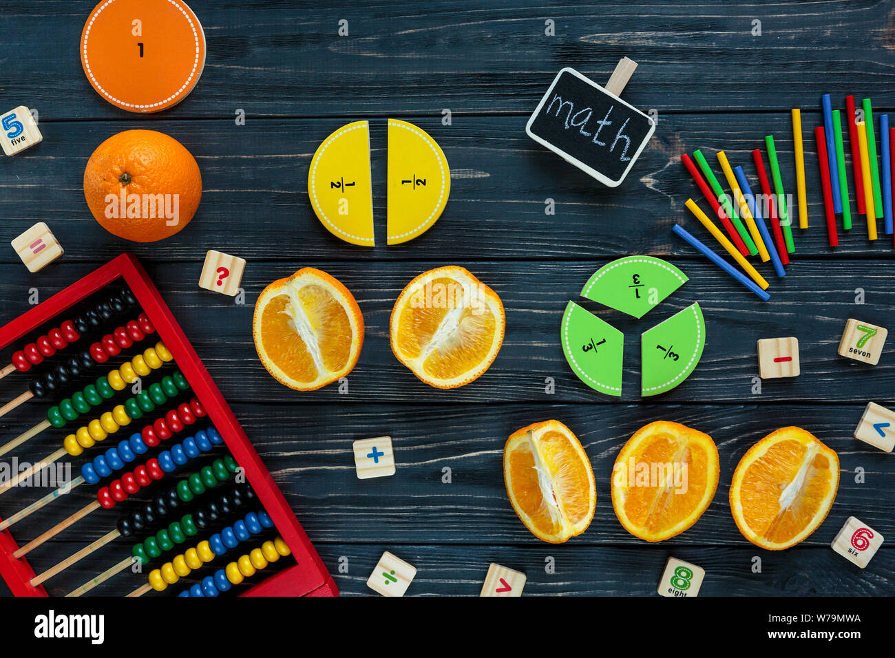 Сolorful mathe Fraktionen und Orangen als Probe auf dunklem Hintergrund oder Tabelle. Interessante kreative lustige Mathe für Kids. Bildung, zurück zu schoo Stockfoto