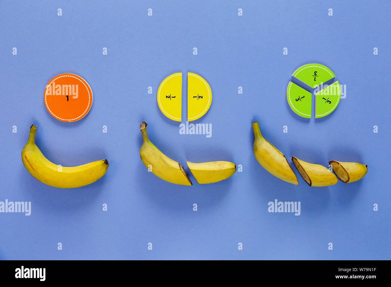Сolorful mathe Fraktionen und Bananen als Probe auf Violett Holz- Hintergrund oder Tabelle. Interessante Mathe für Kids. Bildung, zurück in die Schule. Stockfoto