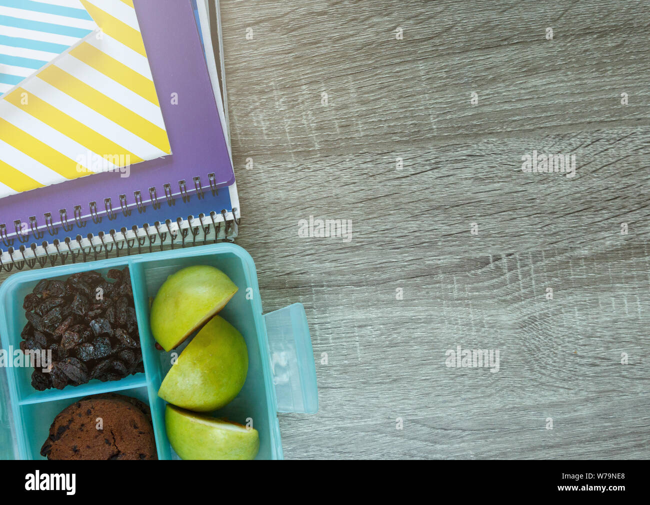 Schule blau Lunch Box mit hausgemachten Sandwiches, grüner Apfel, Cookies, Bleistifte, Uhr, Notebooks auf dem Tisch. Gesunde Ernährung in der Schule. Zurück zur Schule Stockfoto