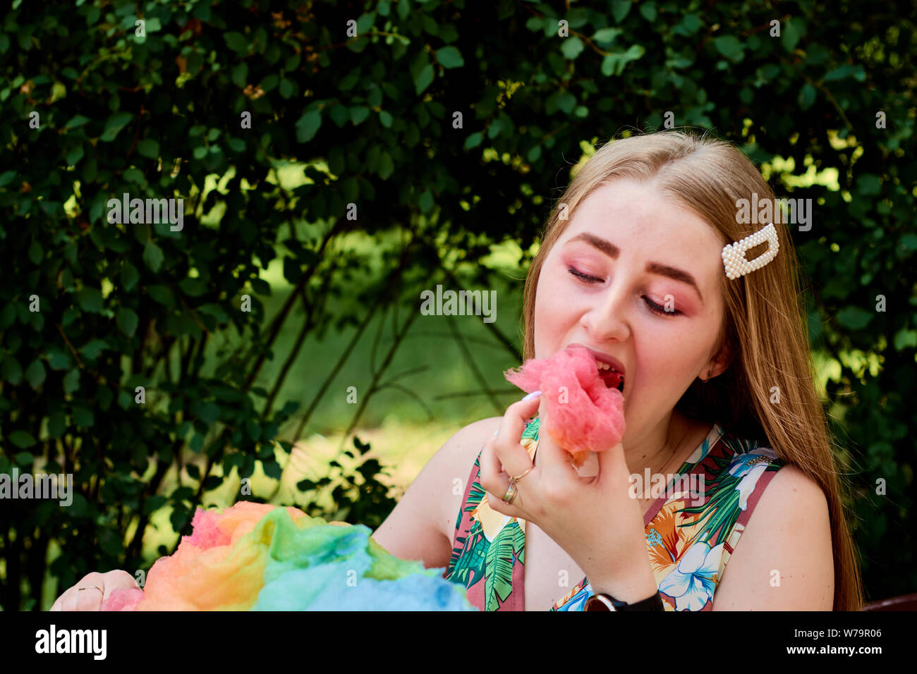 Glückliche freudige schöne junge Frau mit Zuckerwatte, gesponnen Zucker, Zuckerwatte im Park im Sommer. Sommer Veranstaltungen. Sommer Urlaub. Ferienhäuser Tim Stockfoto