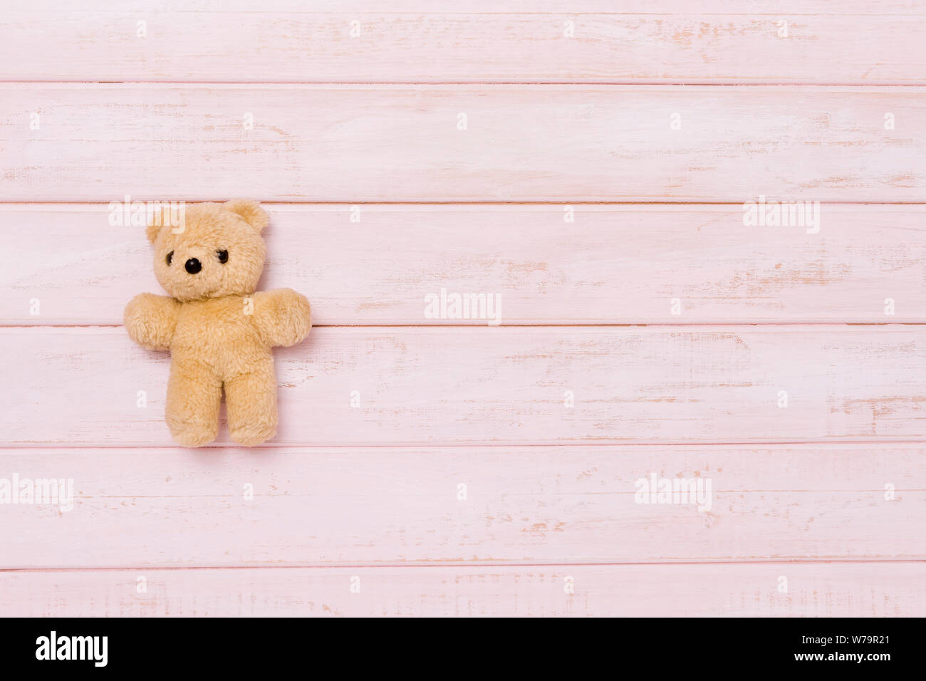 Kleine Teddybär auf rosa Hintergrund Holz, Ansicht von oben Stockfoto