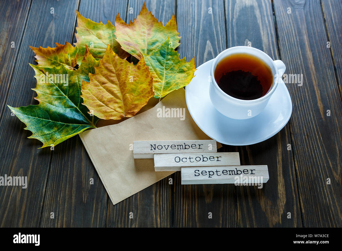 Geöffnet Papier Umschlag auf alten, braunen Holz- Hintergrund mit gelben Blättern. Vintage Stil der Kommunikation. Stockfoto