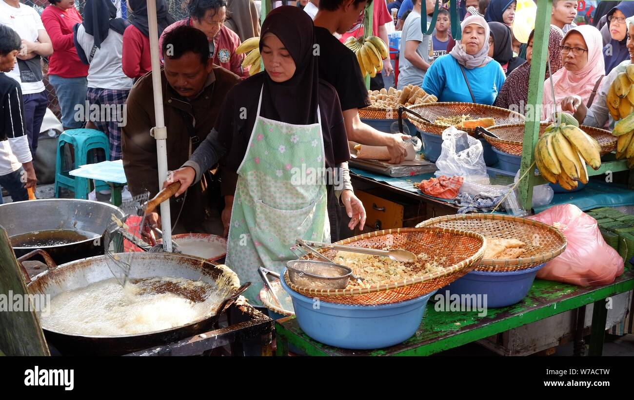 Jakarta, Indonesien - August 2019: Eine muslimische Frau sind braten Bananen zu verkaufen, während die Käufer warten. Stockfoto