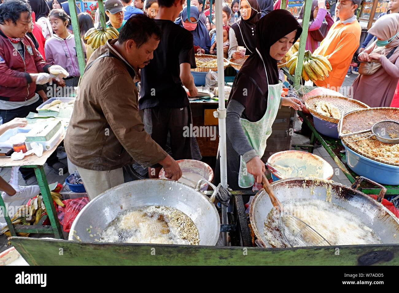 Jakarta, Indonesien - August 2019: ein Mann & Frau Paar braten Snacks zum Verkauf im eigenen Street Food stand. Stockfoto