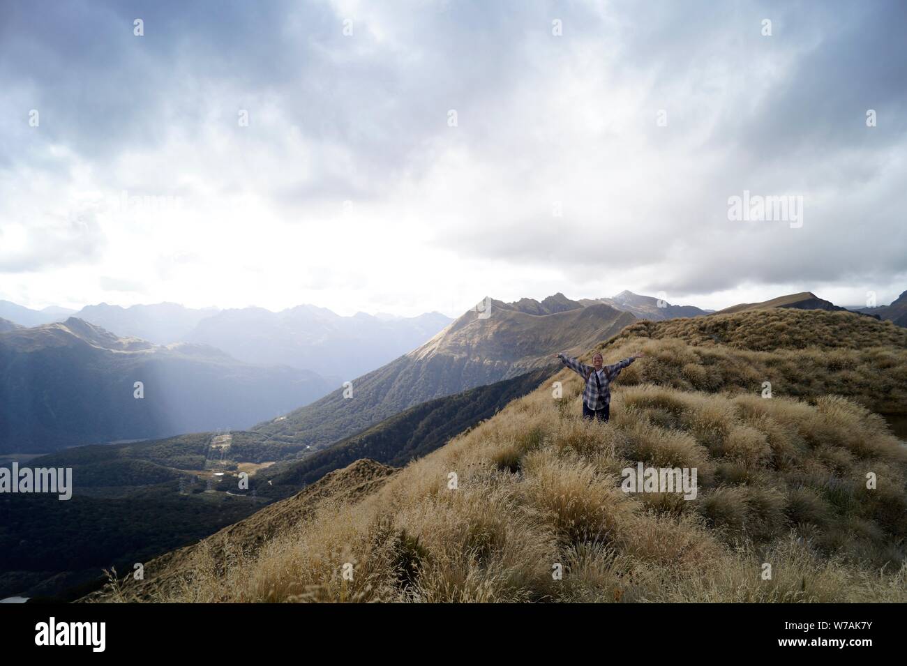 Frau steht auf Mt Burns Titel ridge mit Waffen im Triumph öffnen Stockfoto