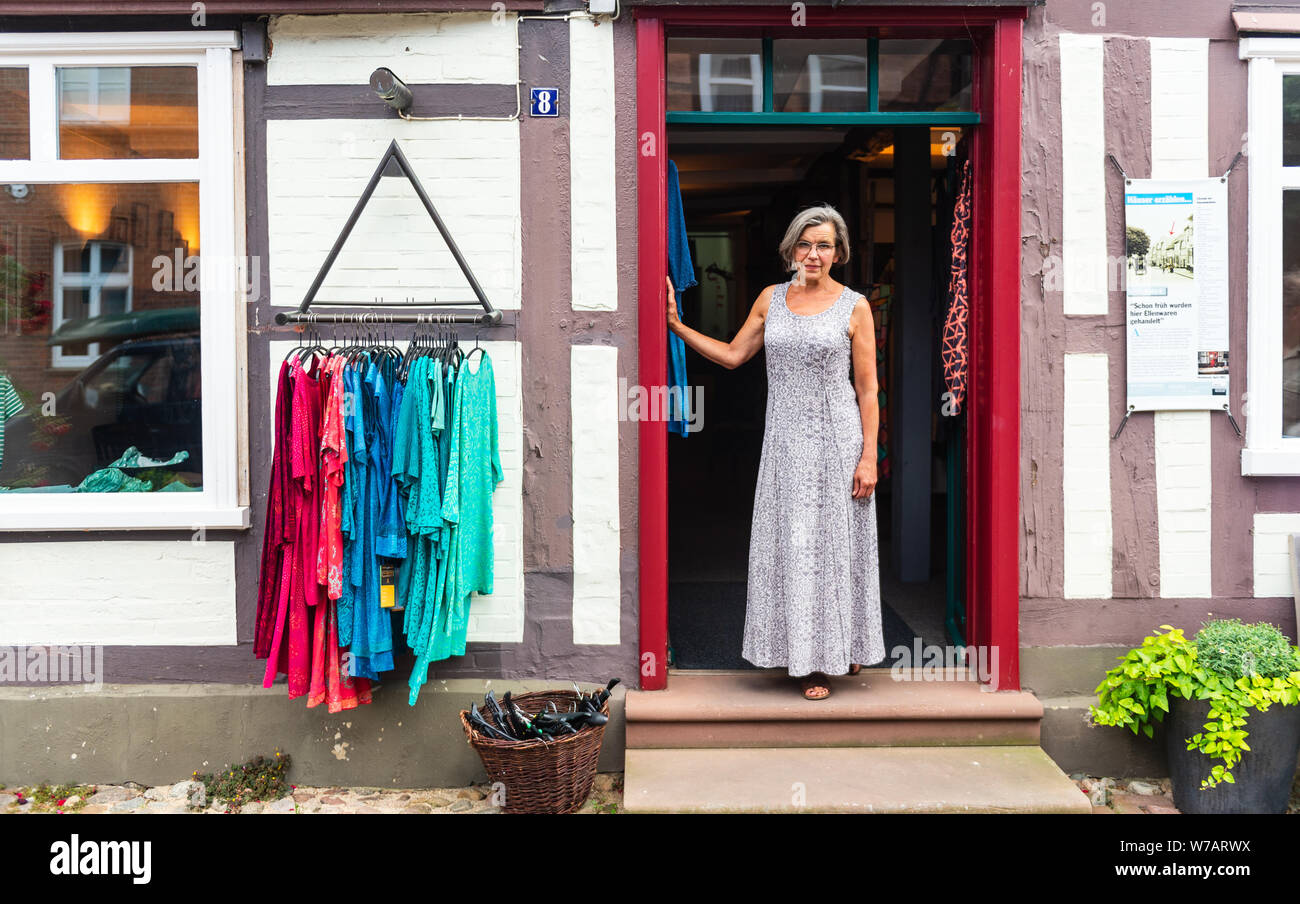 Hitzacker, Deutschland. 01. Juli, 2019. Birgit Holsten vor ihr Shop und ist eine der sogenannten Insel Einkaufen in der Altstadt von Hitzacker. Die alte Stadt liegt an der Elbe, von zwei Armen des kleinen Jeetzel, die wiederholt zu Überflutungen bei Hochwasser led eingerahmt. Credit: Philipp Schulze/dpa/Alamy leben Nachrichten Stockfoto