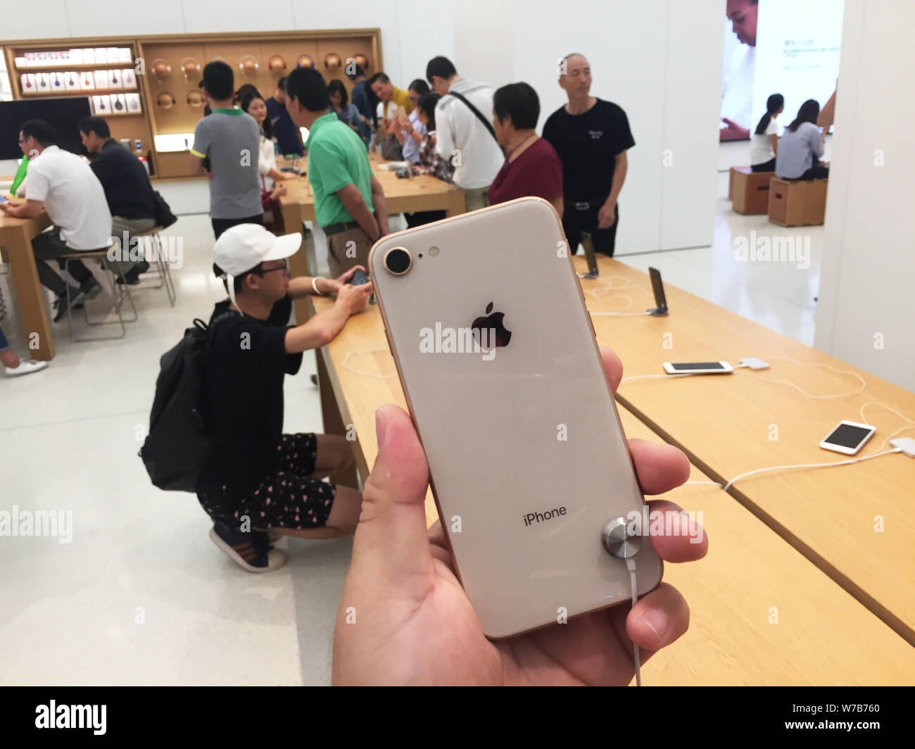 ---- Ein Kunde versucht, einem iPhone 8 Smartphone in einem Apple Store in Shanghai, China, 23. September 2017. Mitarbeiter in einem Apple Store in Shang Stockfoto