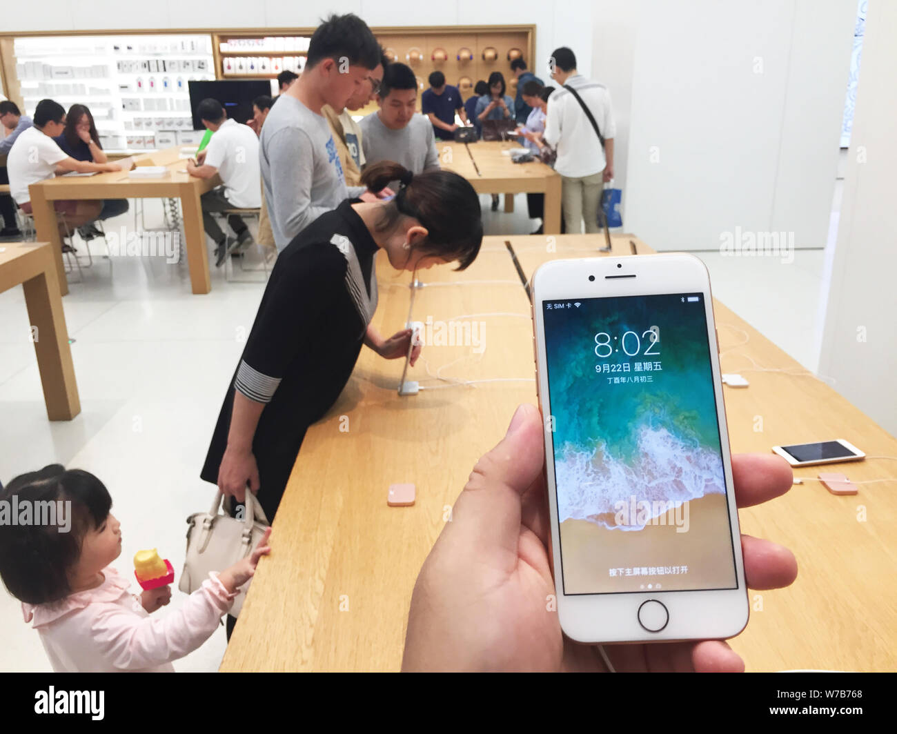 ---- Ein Kunde versucht, einem iPhone 8 Smartphone in einem Apple Store in Shanghai, China, 23. September 2017. Mitarbeiter in einem Apple Store in Shang Stockfoto