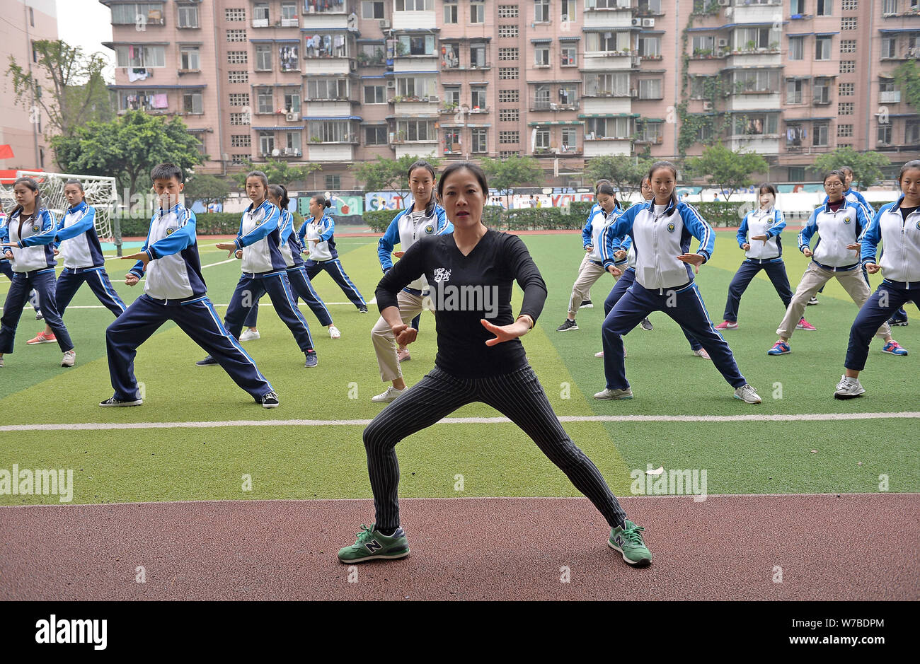 Die Teilnehmer führen Sichuan Oper inspirierte Calisthenics, erstellt von Sichuan Oper Meister Peng Denghuai, an einer High School in Chengdu City, im Südwesten von China Stockfoto