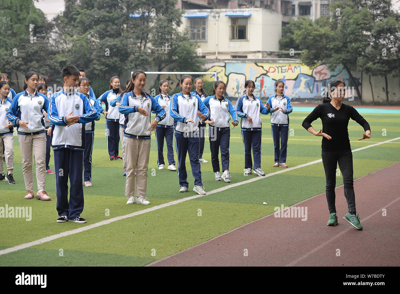 Die Teilnehmer führen Sichuan Oper inspirierte Calisthenics, erstellt von Sichuan Oper Meister Peng Denghuai, an einer High School in Chengdu City, im Südwesten von China Stockfoto