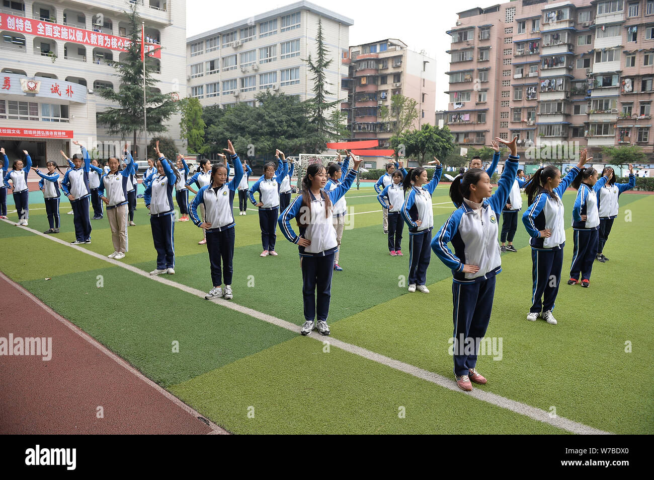 Die Teilnehmer führen Sichuan Oper inspirierte Calisthenics, erstellt von Sichuan Oper Meister Peng Denghuai, an einer High School in Chengdu City, im Südwesten von China Stockfoto