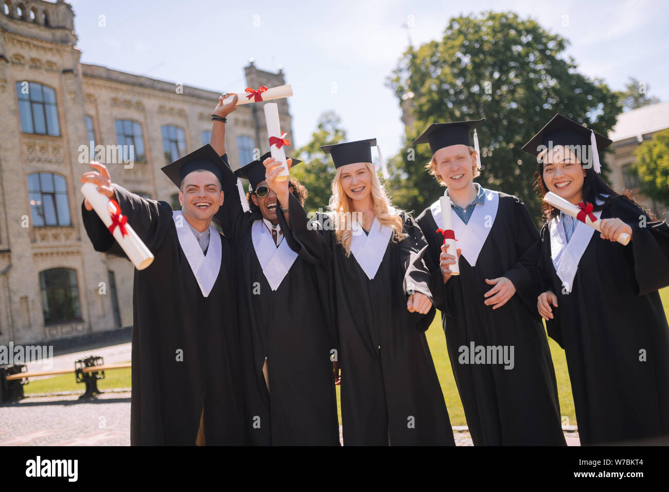 Fröhliche Studenten ihren Abschluss feiern von der Universität. Stockfoto