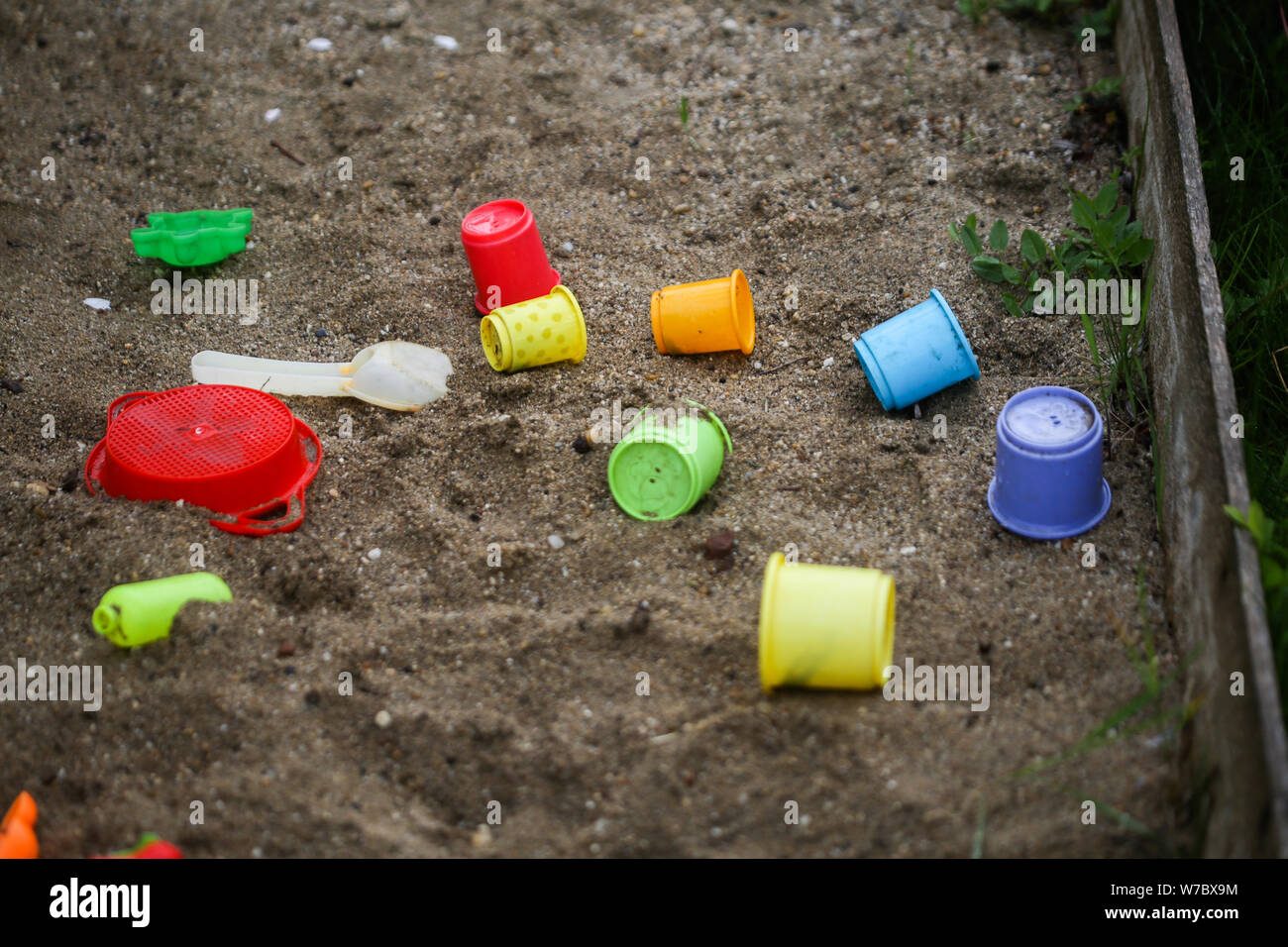 Plastikspielzeug in feuchten Sand Grube während eines regnerischen Tag Stockfoto