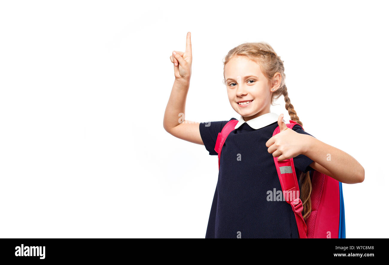 Fröhlich 8 Jahre alte Schülerin mit Rucksack tragen Uniform, die auf weißem Hintergrund. Bereit für die Schule Stockfoto