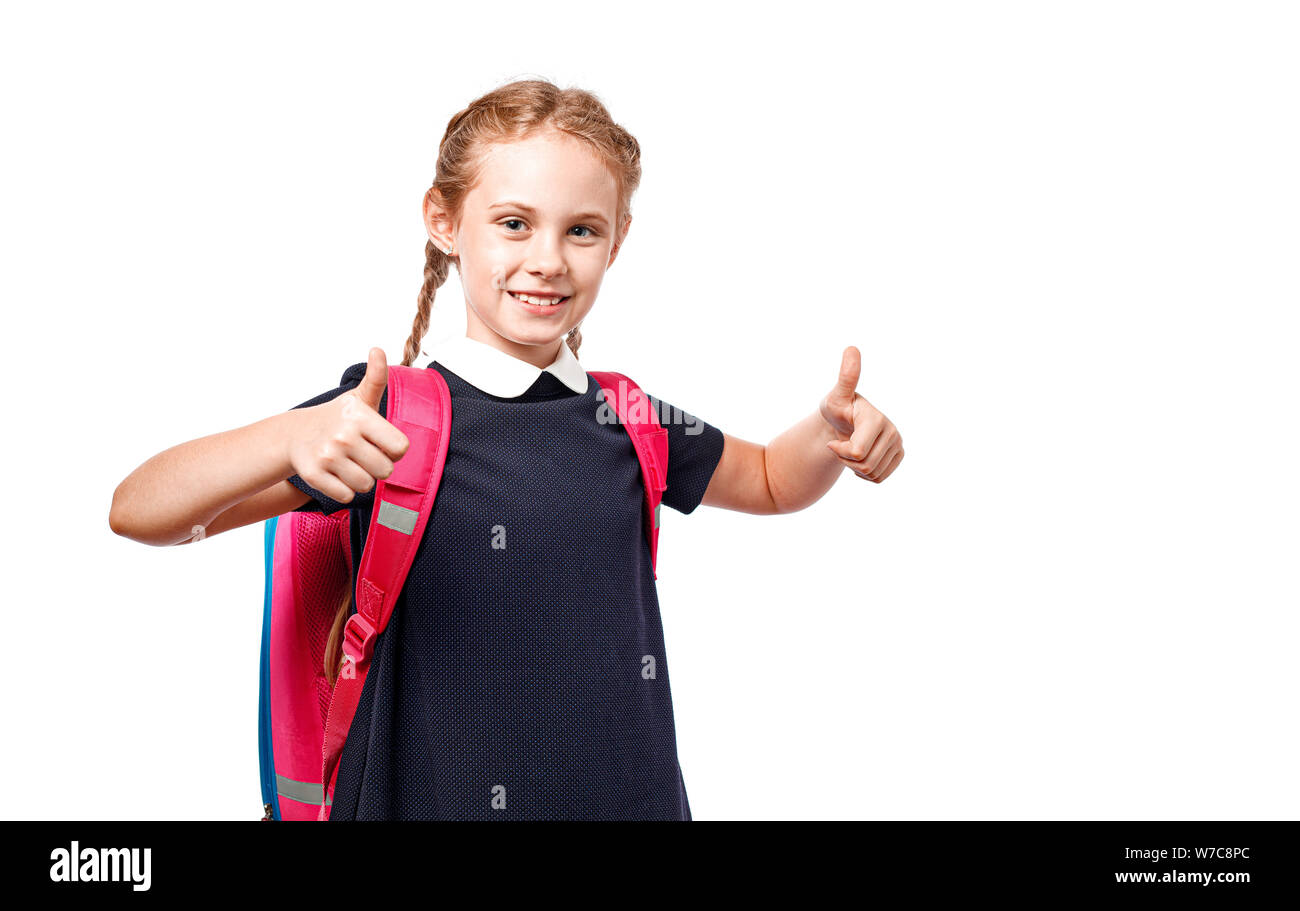 Fröhlich 8 Jahre alte Schülerin mit Rucksack tragen Uniform, die auf weißem Hintergrund. Bereit für die Schule Stockfoto