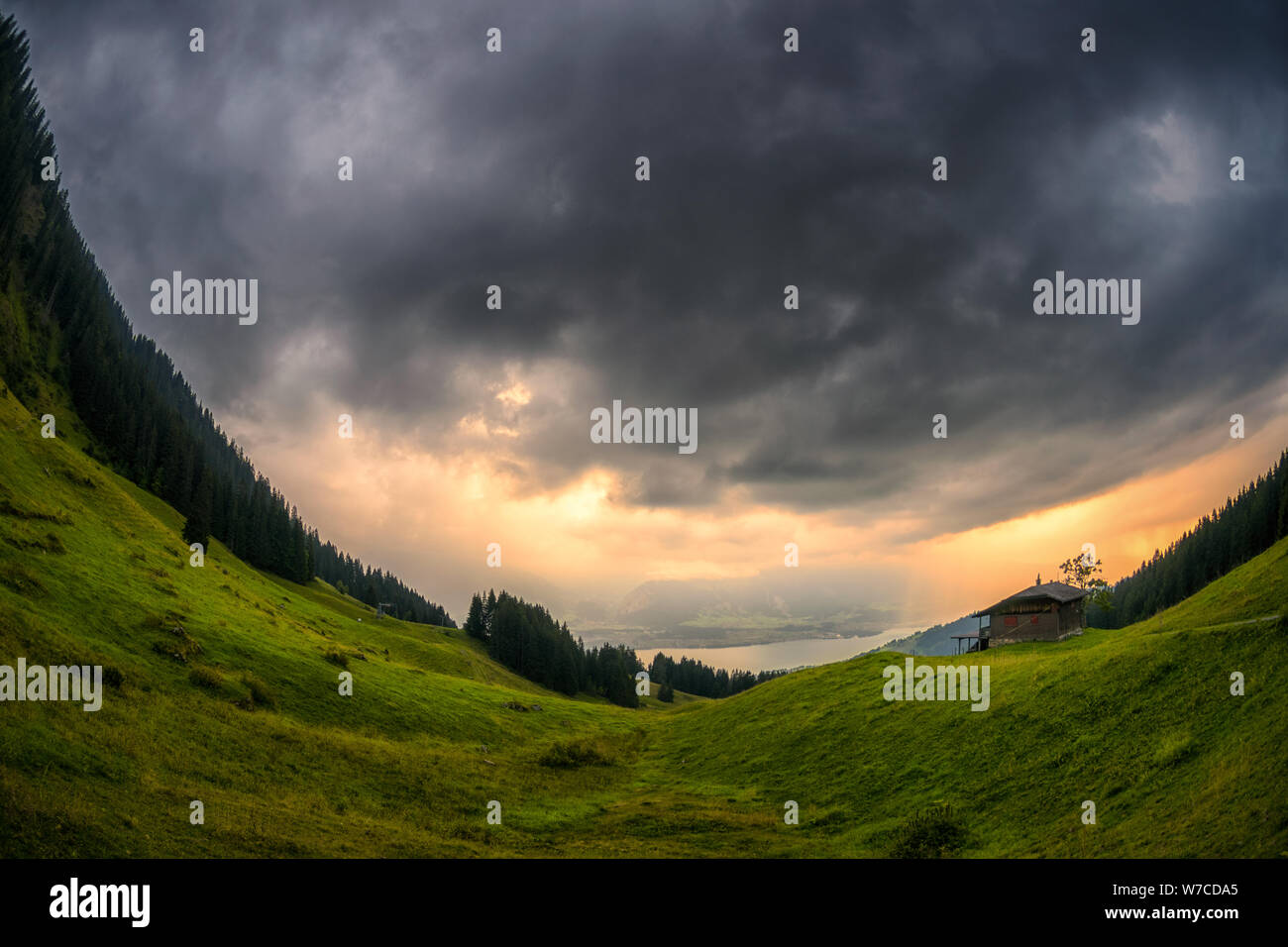 Fisheye Landschaft Schuß zu Wileralmi und Thunersee auf einer thundery Abend mit Sonnenstrahlen im Hintergrund Stockfoto