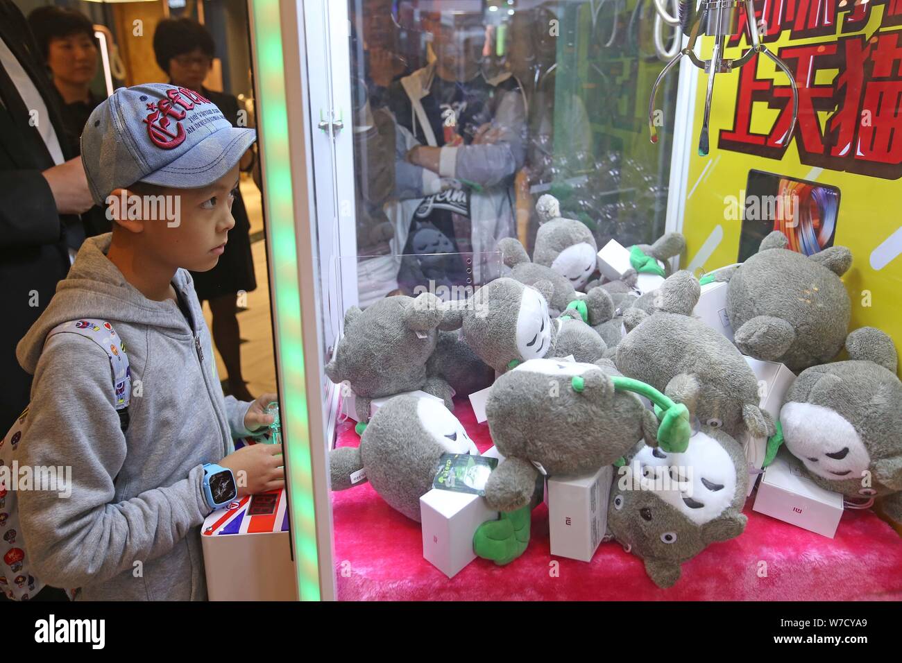 Kunden erhalten kostenlosen Hongmi smartphones und Puppen von einer Puppe - ergreifende Maschine an der globalen Harbour Shopping Mall in Shanghai, China, 15. Oktober 2017. Stockfoto