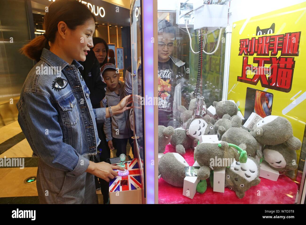 Kunden erhalten kostenlosen Hongmi smartphones und Puppen von einer Puppe - ergreifende Maschine an der globalen Harbour Shopping Mall in Shanghai, China, 15. Oktober 2017. Stockfoto