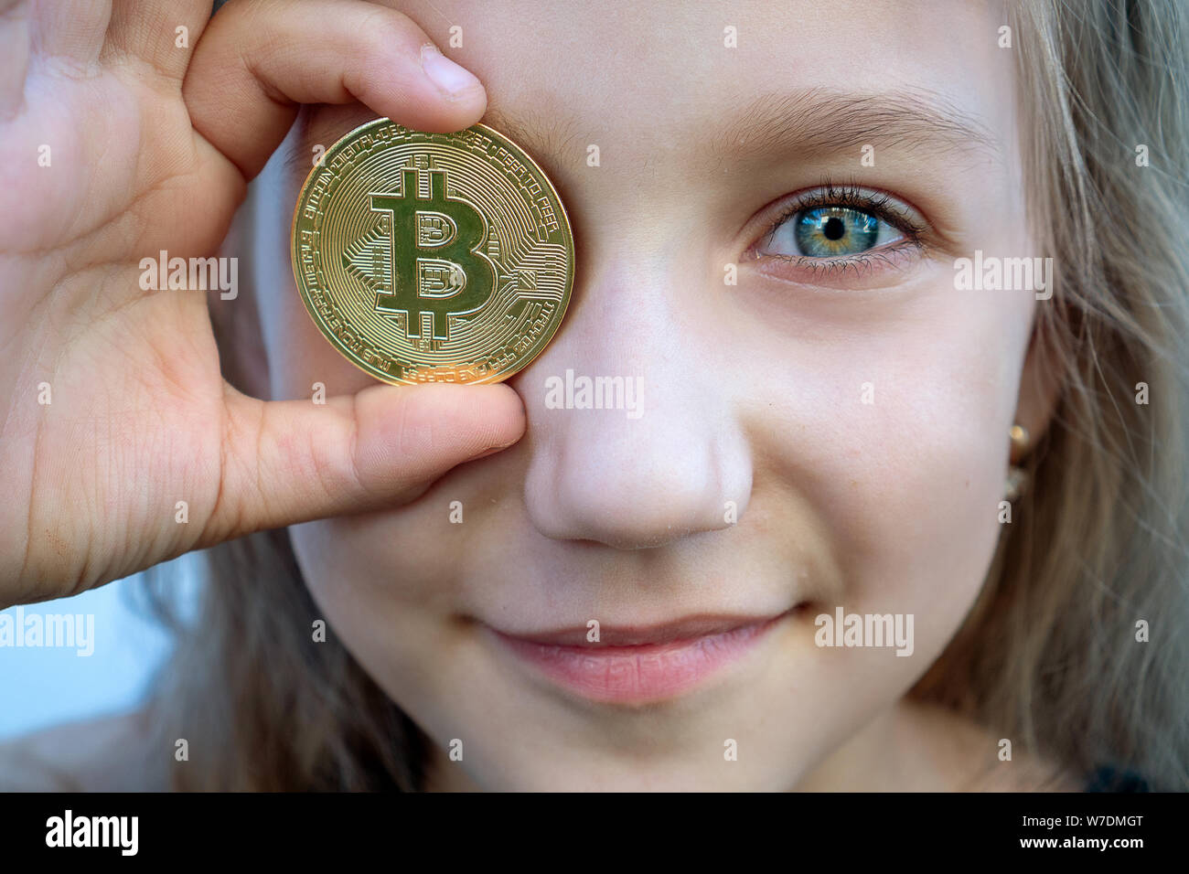 Mädchen Junge mit grünen Augen holding Bitcoin digitales Geld. Konzept der einfachen Bitcoin investieren und Handel. Close-up. Stockfoto