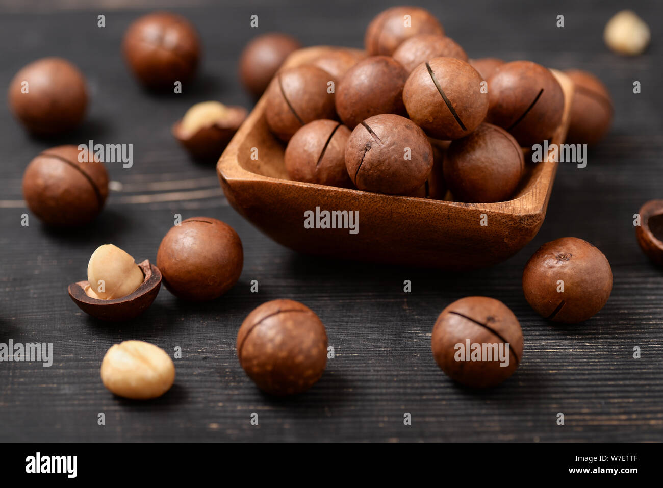 Nahaufnahme von Macadamia-nüssen auf schwarzen Holztisch Stockfoto