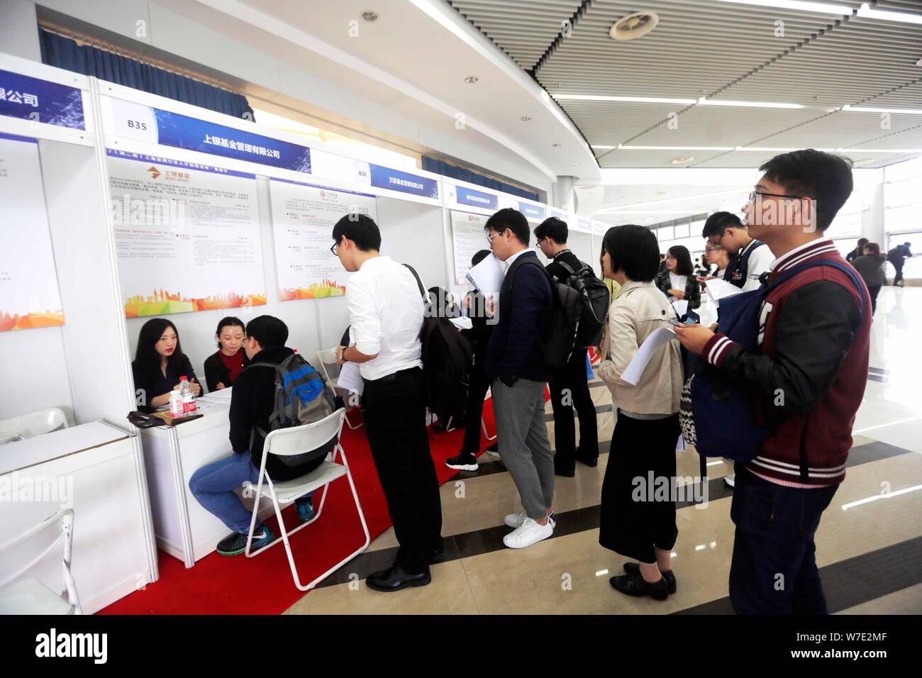 Chinesische Arbeitsuchende sprechen Sie mit Interviewer für Beschäftigung im Finanzsektor an einem Job Messe in Shanghai, China, 16. Oktober 2017 zu suchen. Eine neue Su Stockfoto