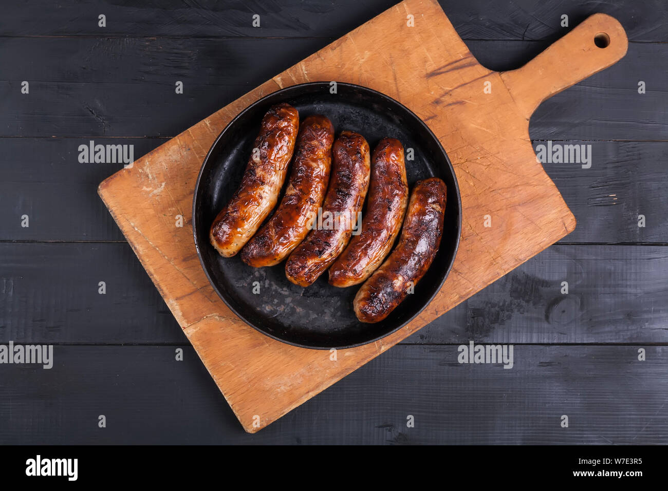 Gegrilltes Hühnchen Würstchen grillen auf einem dunklen Hintergrund Stockfoto