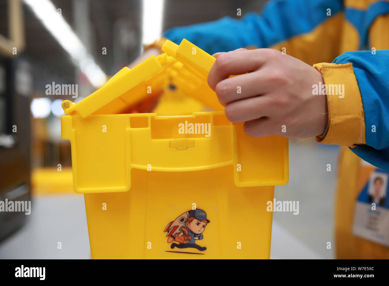 ---- Ein Mitarbeiter ist die Verpackung mit einem wiederverwendbaren Box für Expresslieferungen in einem Lager der Chinesischen Einzelhandelskette Suning Commerce Group Co., Ltd. in Na Stockfoto