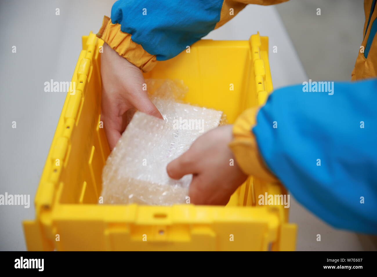 ---- Ein Mitarbeiter ist die Verpackung mit einem wiederverwendbaren Box für Expresslieferungen in einem Lager der Chinesischen Einzelhandelskette Suning Commerce Group Co., Ltd. in Na Stockfoto