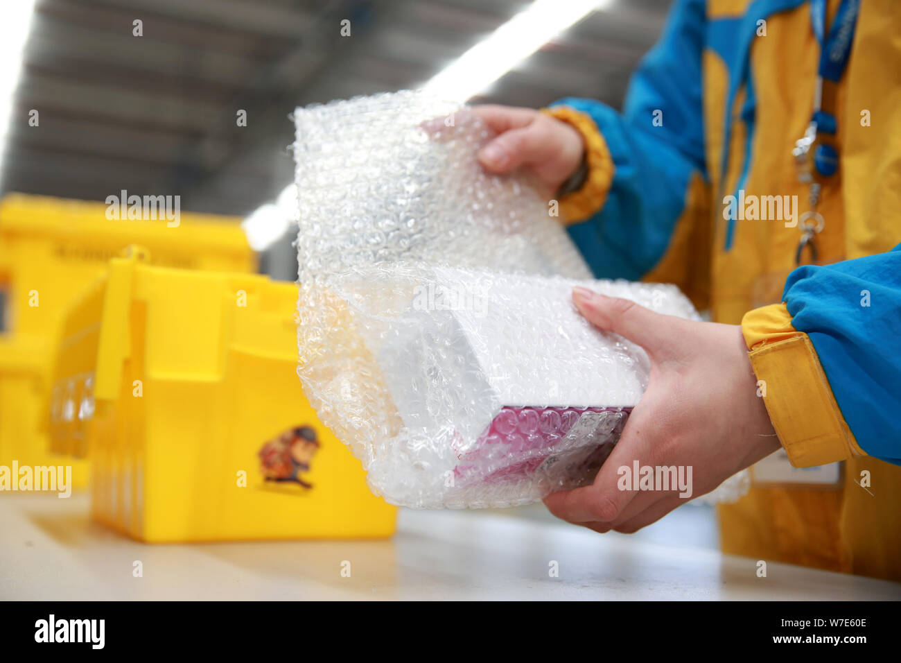 ---- Ein Mitarbeiter ist die Verpackung mit einem wiederverwendbaren Box für Expresslieferungen in einem Lager der Chinesischen Einzelhandelskette Suning Commerce Group Co., Ltd. in Na Stockfoto