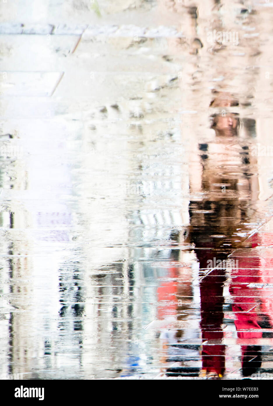 Abstrakte verschwommenen Hintergrund der Reflexion Schatten Silhouette in eine Pfütze, einer Frau, die alleine im Regen Stockfoto
