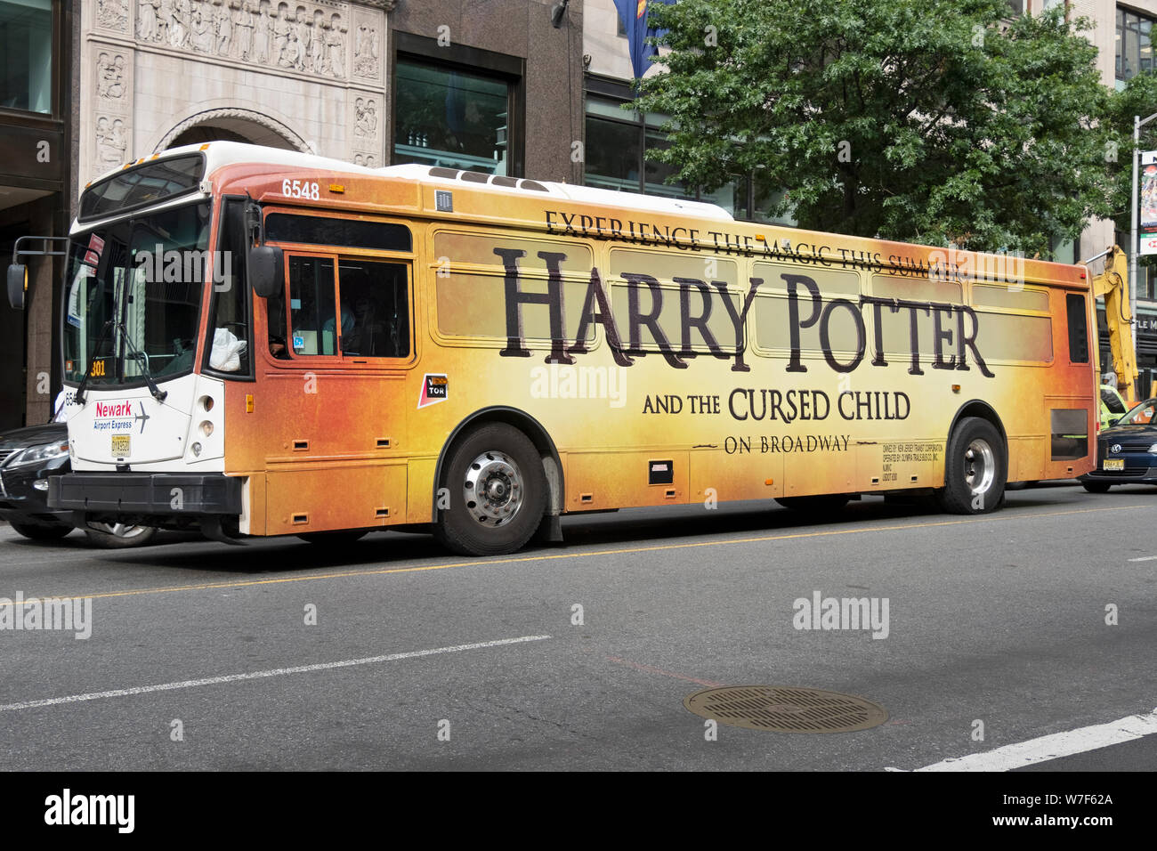 Eine Airport Express Bus mit einem riesigen Werbung für die Harry Potter Spielen auf den Broadway. Auf der West 42nd Street in Manhattan, New York City. Stockfoto
