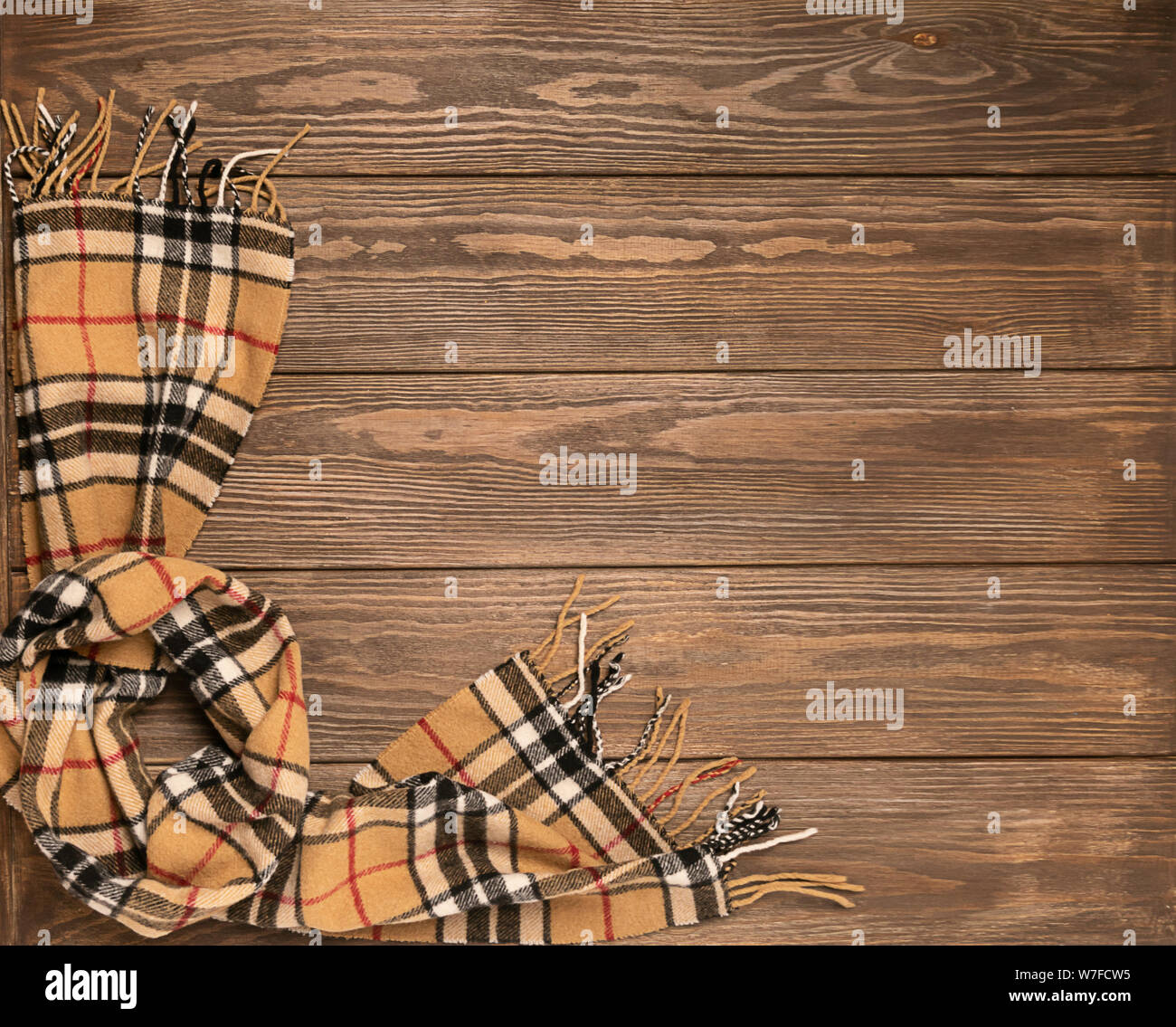 Wollschal mit Muster auf einer hölzernen braunen Hintergrund. Herbst Konzept. Für text Design statt. Flache layout Ansicht von oben. Stockfoto