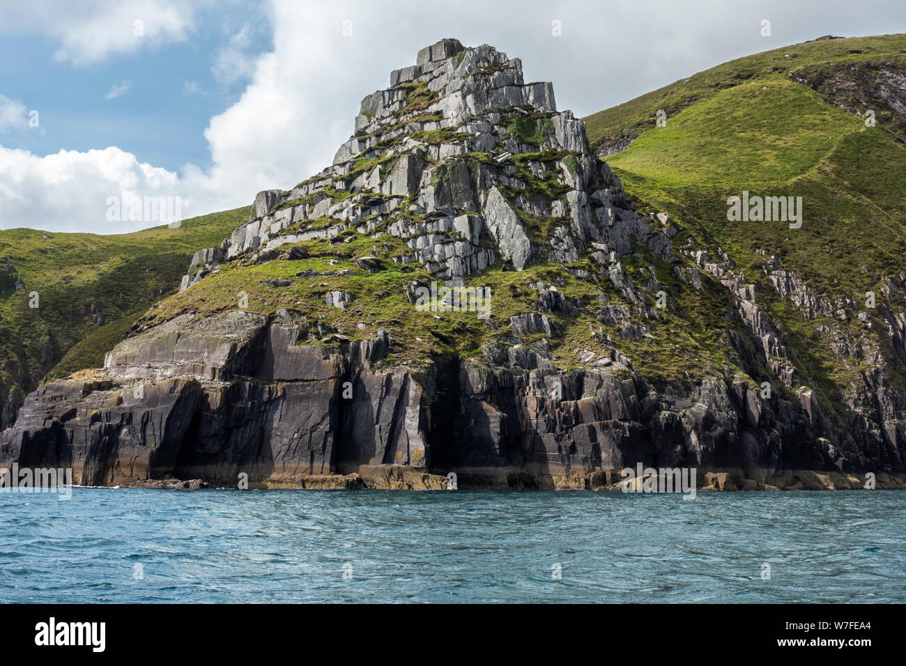 Die zerklüftete Küstenlinie unter Ballymacadoyle Hill vom Boot aus gesehen - der Halbinsel Dingle in der Grafschaft Kerry, Republik von Irland Stockfoto