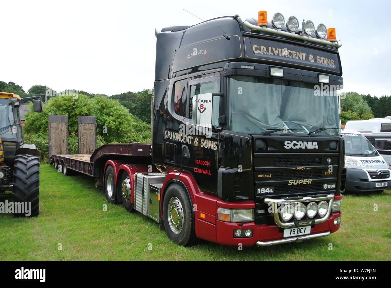 Ein Scania 550 Zugmaschine mit flachen Anhänger bis auf Anzeige an der Torbay Steam Fair, Churston, Devon, England geparkt. UK. Stockfoto