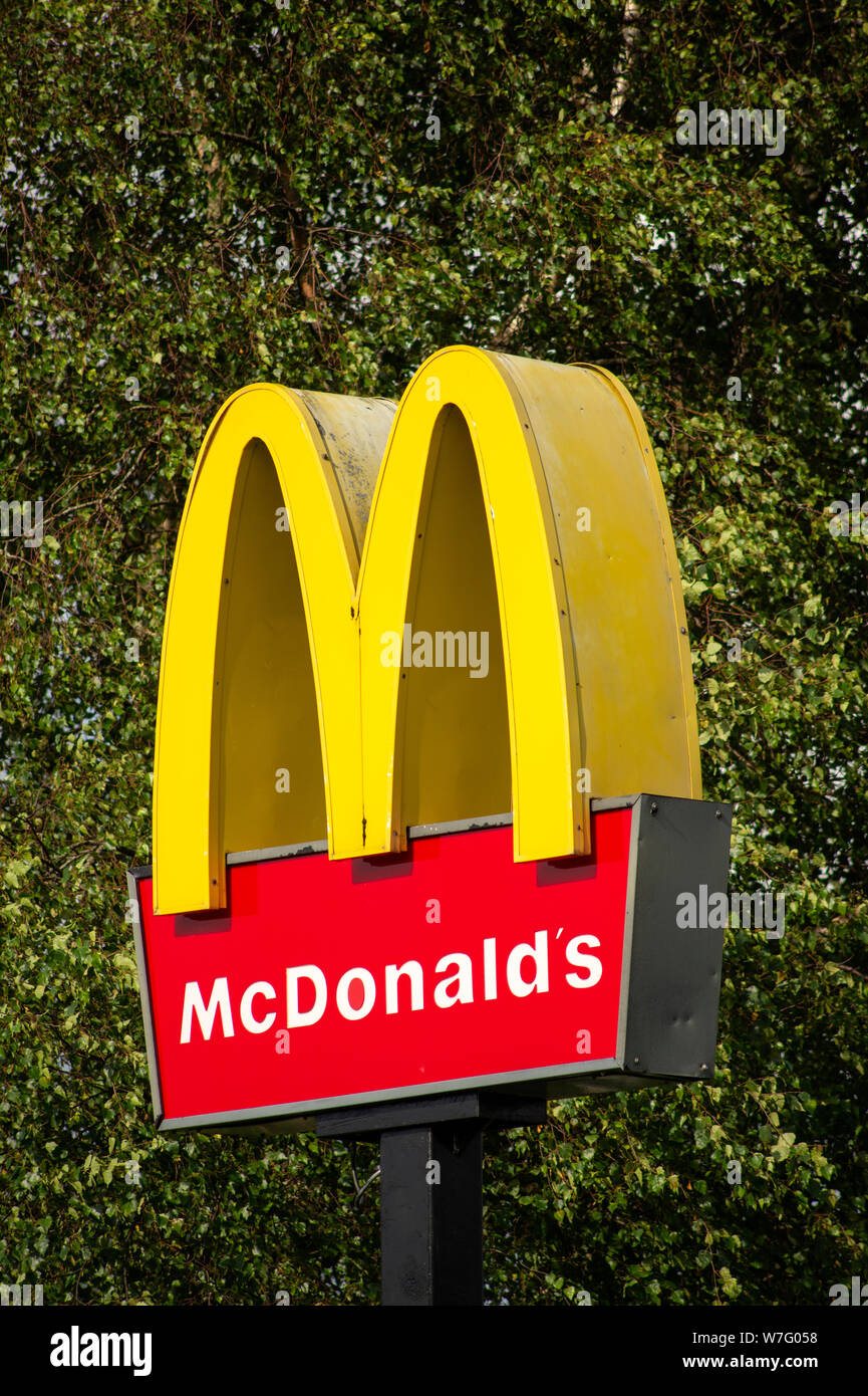 McDonalds Markenlogo vor grünem Baumhintergrund als Kontrastgegenstellung Stockfoto