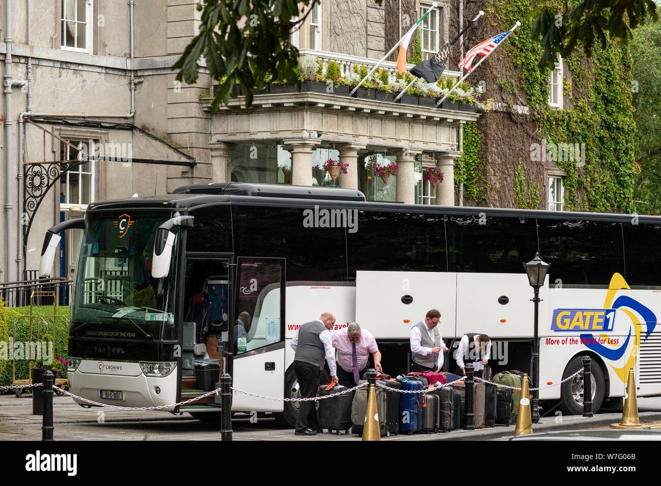 Hotelmitarbeiter laden einen Tourbus von Gate 1 im Great Western Hotel oder ab Malton in Killarney, County Kerry, Irland, aus. Stockfoto