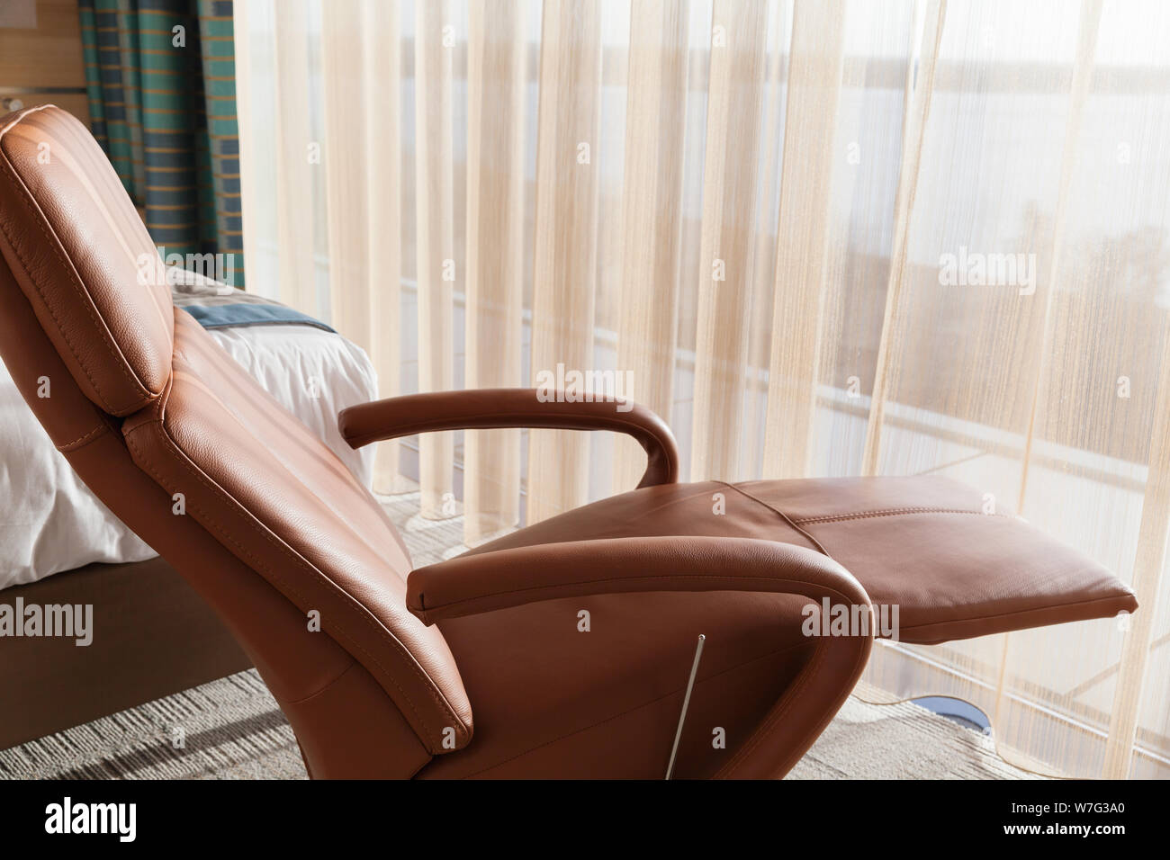 Komfortable, luxuriöse Leder Sessel steht in einem leeren Raum durch das Fenster Stockfoto