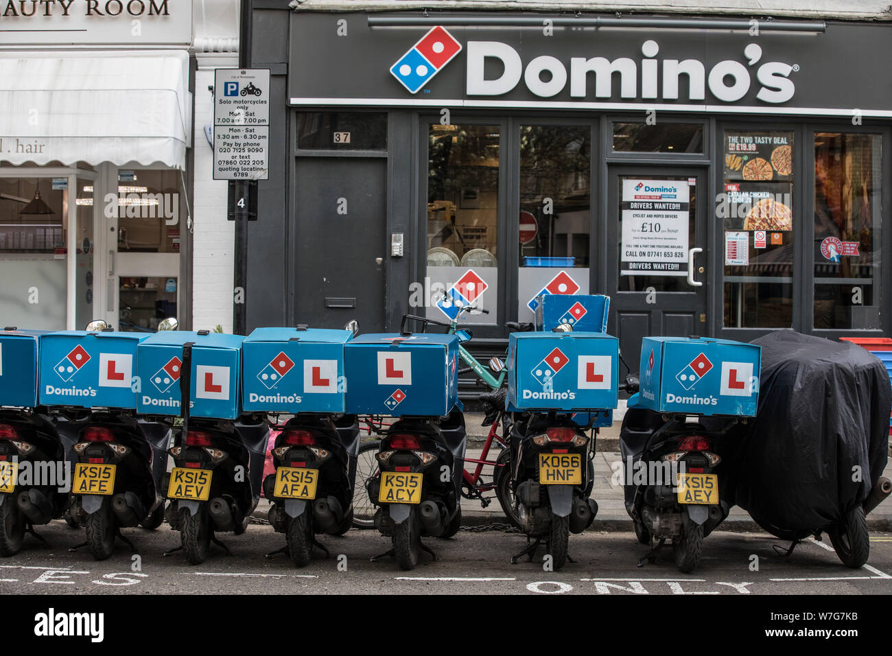 Domino's Pizza Delivery Roller untätig außerhalb einer Niederlassung auf Foley Street, London, UK Stockfoto