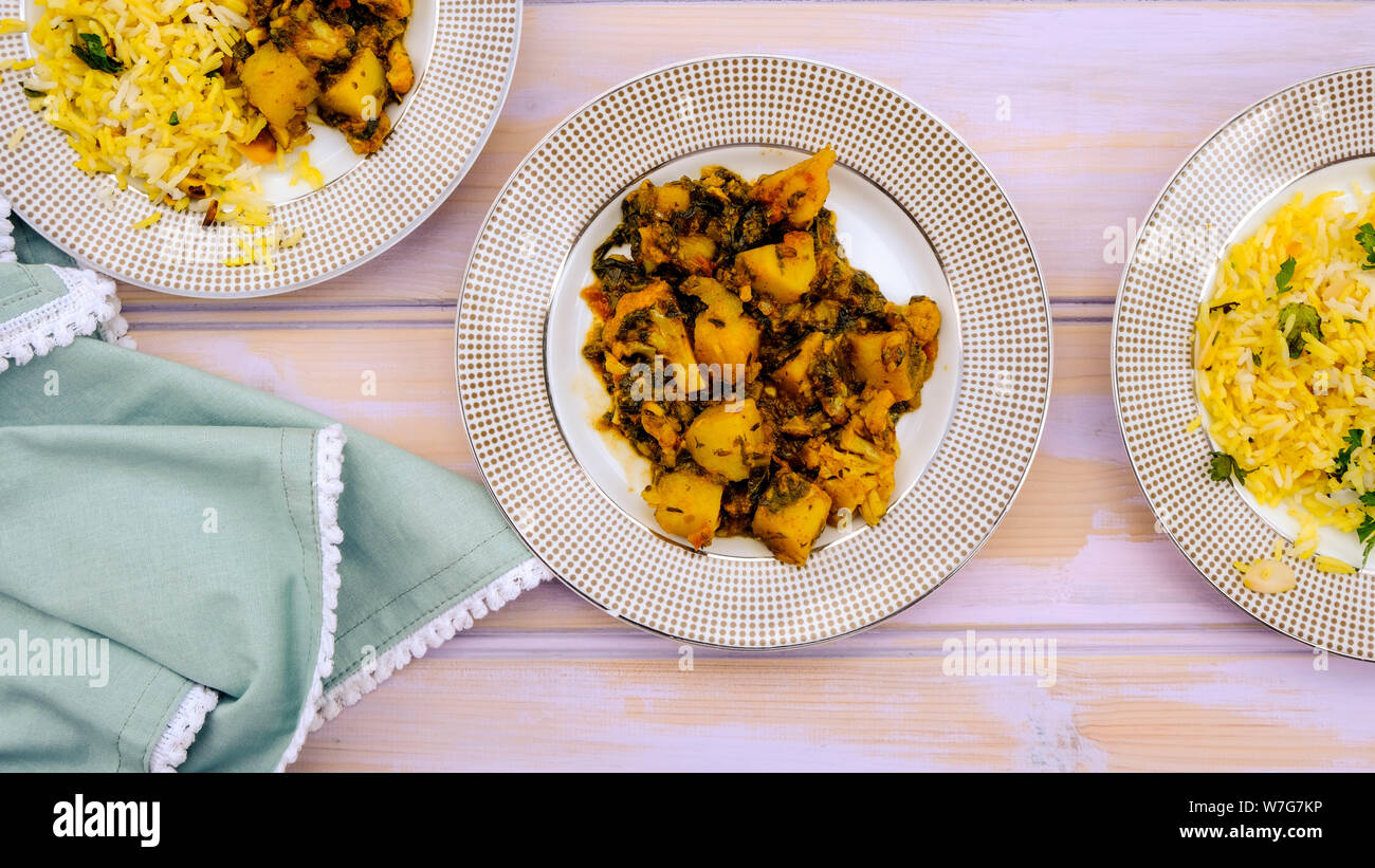 Im indischen Stil vegetarische Aloo Gobi Saag, Kartoffeln, Blumenkohl und Spinat in pikanter Soße mit Reis Stockfoto