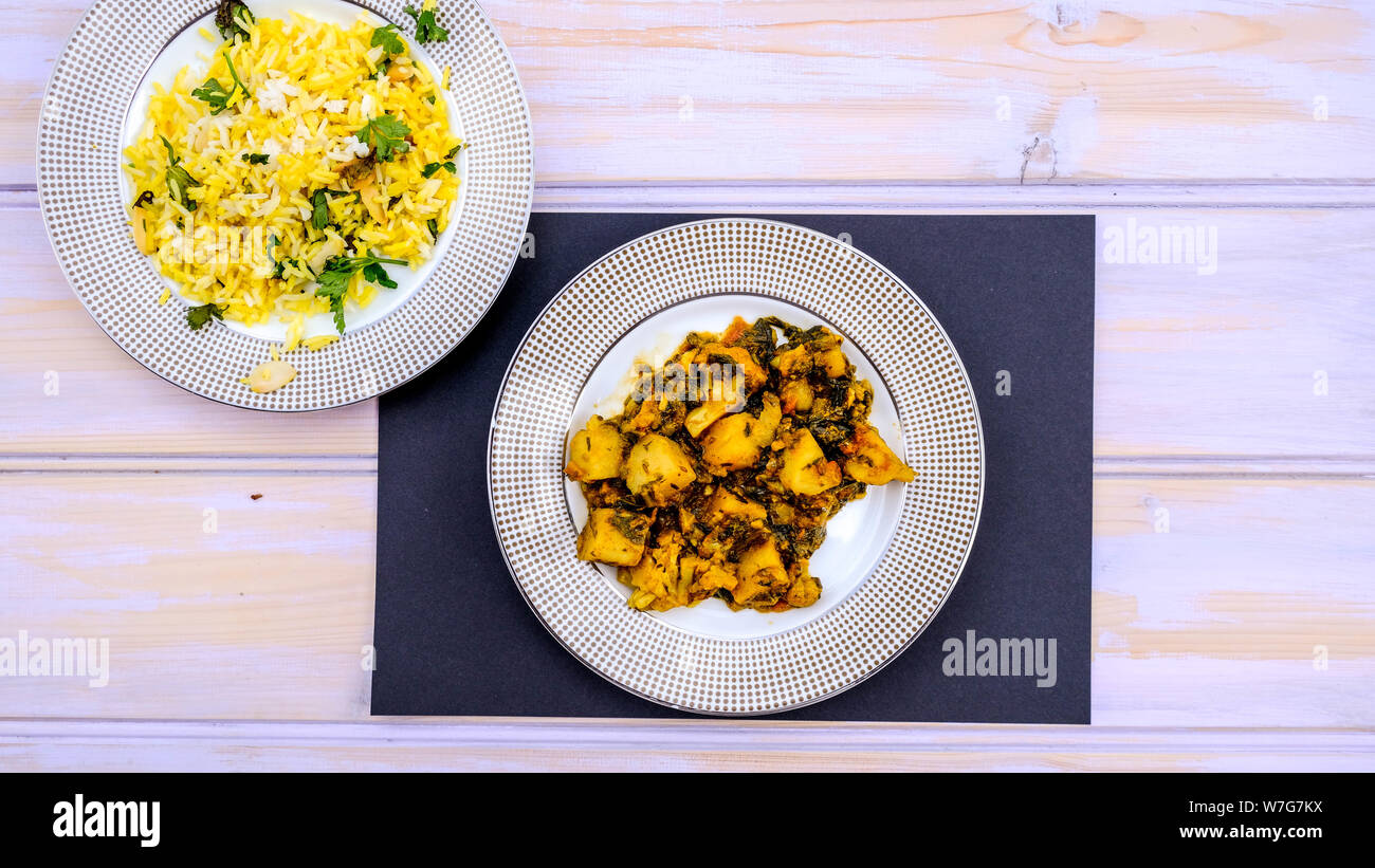 Im indischen Stil vegetarische Aloo Gobi Saag, Kartoffeln, Blumenkohl und Spinat in pikanter Soße mit Reis Stockfoto