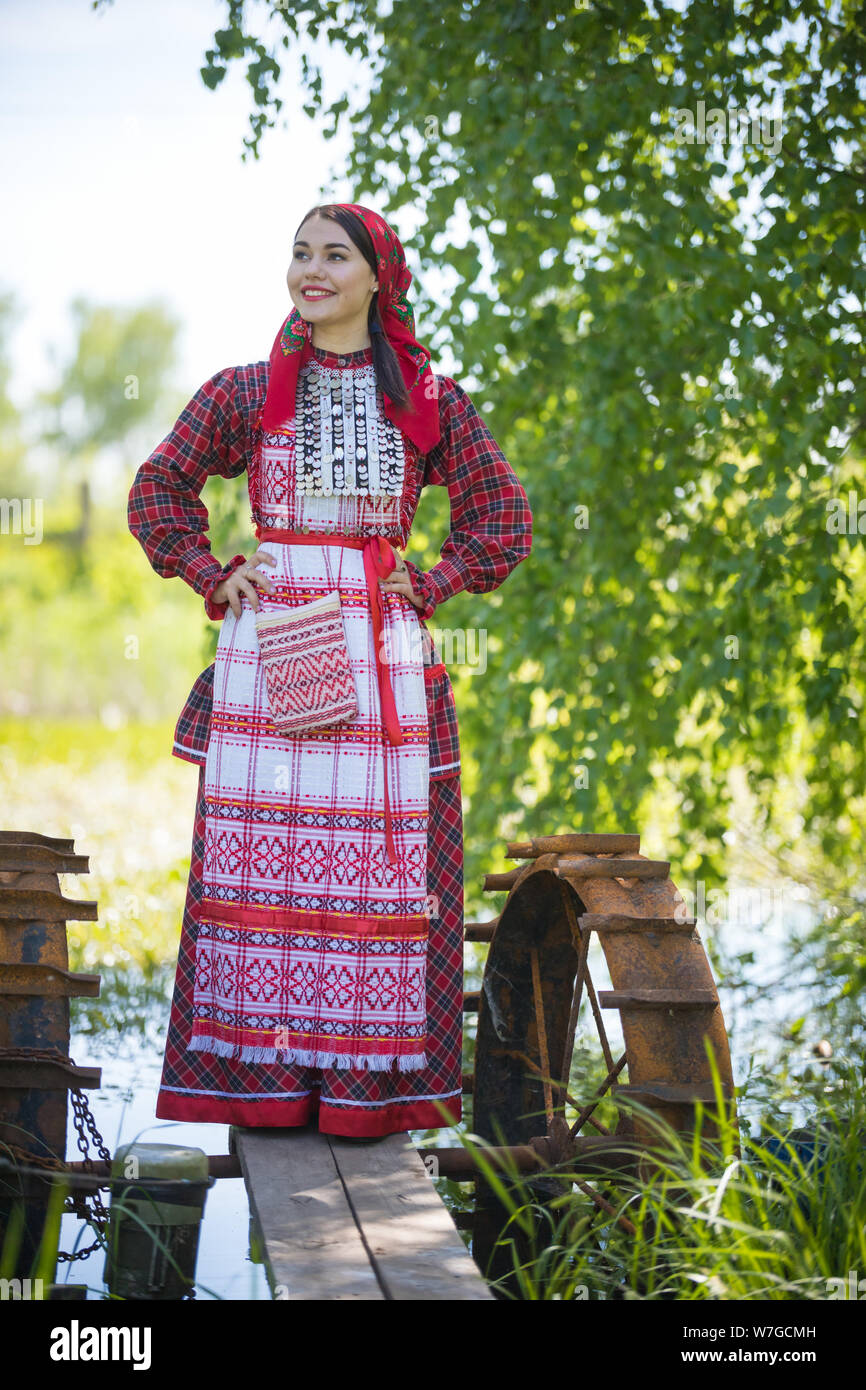 Junge Frau in Schal und traditionelle russische Kleidung steht auf einem  kleinen Pier in der Nähe des Sees, und hält die Hände auf eine Taille  Stockfotografie - Alamy