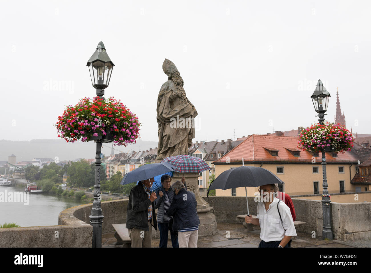 Menschen mit Regenschirm ist Chatten an der Alten Brücke über den Main in Regen Wetter in Würzburg, Deutschland Stockfoto