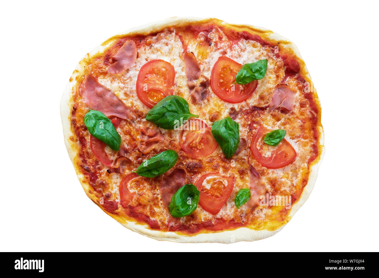 Blick von oben auf die frische, hausgemachte Pizza mit Serrano Schinken, in Scheiben geschnittene Tomaten und Basilikum auf weißem Hintergrund Stockfoto