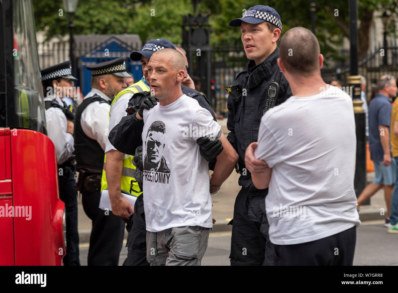 Verhaftet demonstrant am Freien Tommy Robinson Protestkundgebung in London, UK. Polizei weg weiße Kaukasier Männlich unter Anhalten. Kostenlose Tommy Shirt Stockfoto