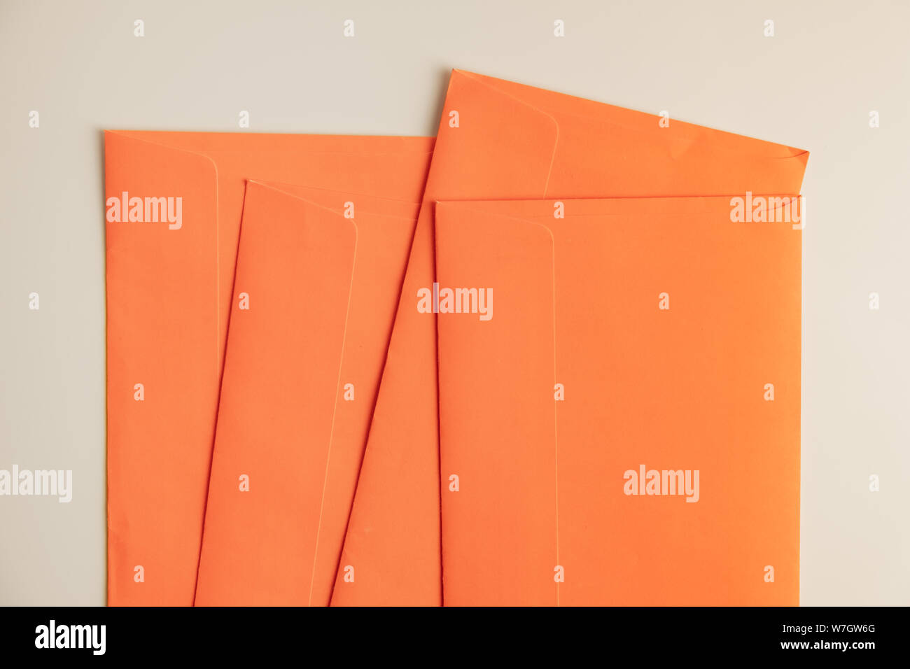 Orange Umschläge in weißer Hintergrund, Ansicht von oben. Abstraktes Bild der post Paket, Konzept der Kommunikation und Mailinglisten. Stockfoto