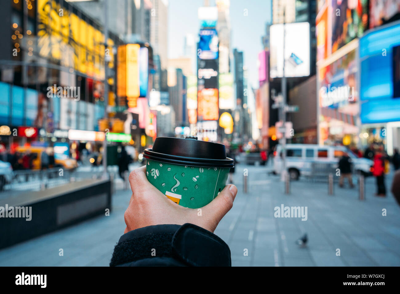Detail einer Hand mit einem grünen Kaffee Glas mit New York City im Hintergrund - wunderschöne Stadt mit verschwommenen Farben - Close-up Stockfoto