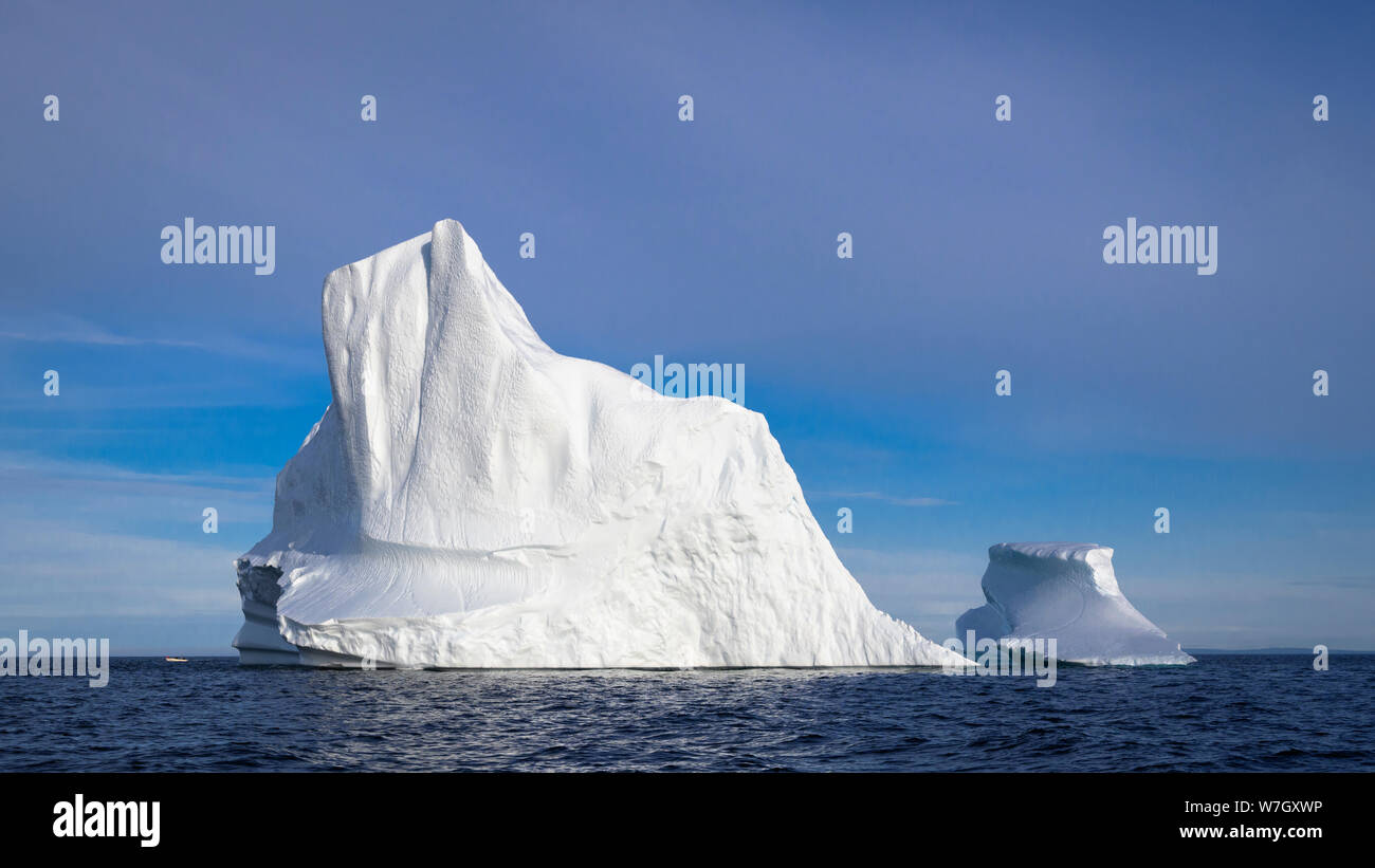 Eisberg vor der Küste von Neufundland, Kanada. Mit Fischerboot an Für die Skala links. Stockfoto