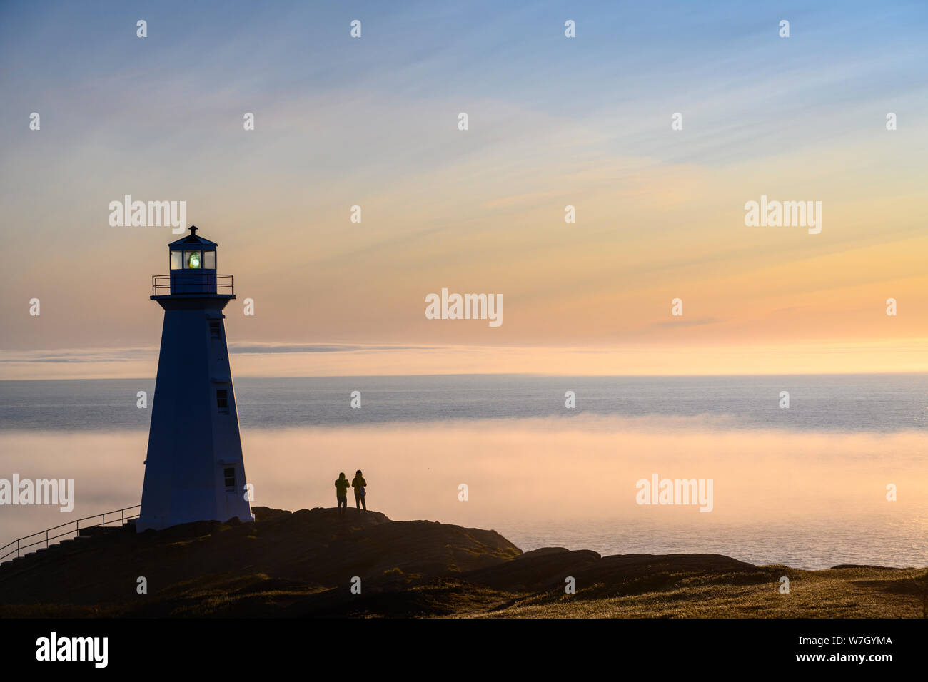 Besucher am Cape Spear Leuchtturm mit Nebelbank über dem Atlantik; St. John's, Neufundland, Kanada. Stockfoto