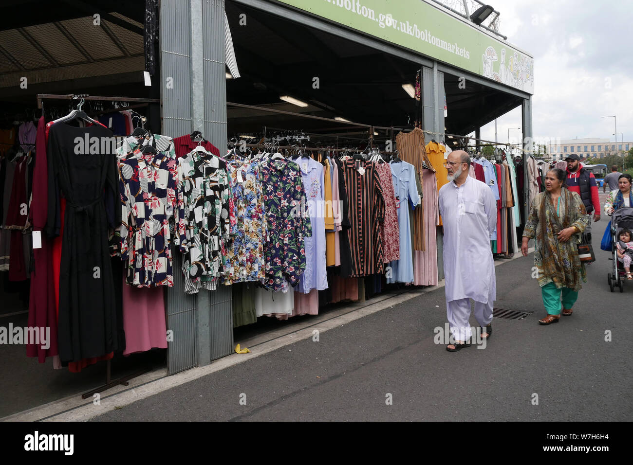 Shopping für asiatische Frauen Mode und Material auf einem Markt im Freien in Bolton, Lancashire, Greater Manchester, England, UK,. foto DON TONGE Stockfoto